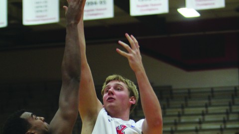 Bobby Hain (20) attempts a contested jump shot against Oberlin College’s Randy Ollie (25) during the Penguins’ basketball game on Nov. 16. Photo by Dustin Livesay/ The Jambar.