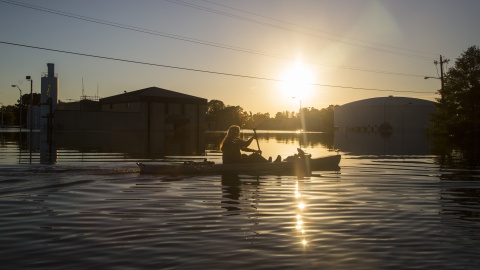 Photo courtesy of Travis Long/Raleigh News & Observer/TNS. Buckley Miller paddles a canoe past a flooded water treatment plant in downtown Lumberton, N.C., after Hurricane Matthew caused downed trees, power outages and massive flooding along the Lumber River, on Tuesday, Oct. 11, 2016. (Travis Long/Raleigh News & Observer/TNS)